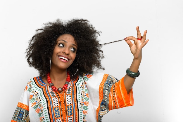 Junge schöne afrikanische Frau mit Afro-Haaren, die traditionelle Kleidung tragen