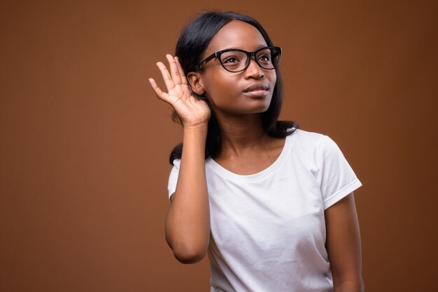 Junge schöne afrikanische Zulu Frau gegen braunen Hintergrund