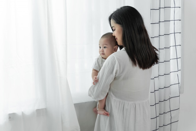 Junge schöne aisan Mutter mit ihrem kleinen netten neugeborenen Baby