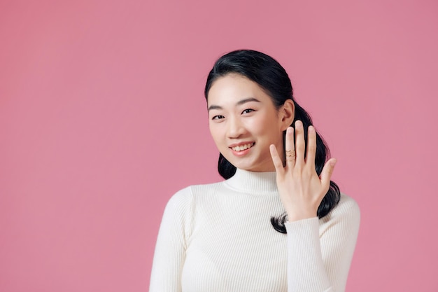 Junge schöne asiatische Frau, die ihren Verlobungsring zeigt