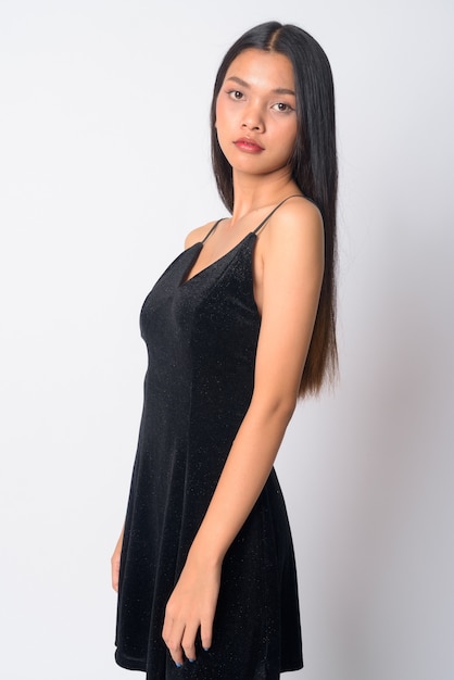 junge schöne asiatische Frau, die schwarzes ärmelloses Kleid trägt