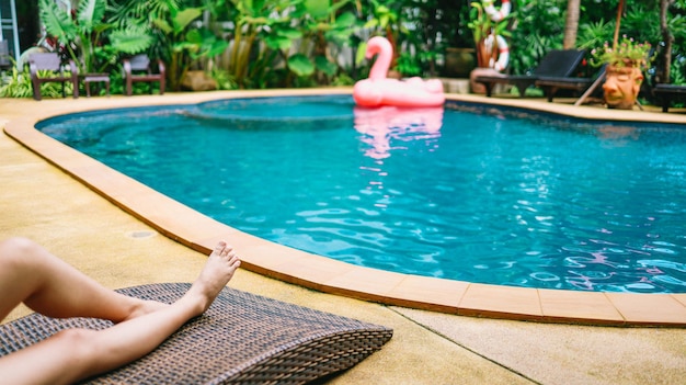 Junge, schöne, asiatische Frau entspannt sich im Schwimmbad eines Spa-Resorts. Schönes, tropisches Hotel am Strand mit Schwimmbad.