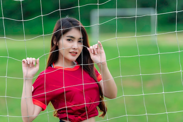 Junge schöne asiatische Frau trägt Fußballspieler jubeln sportFemale Fans Fußball jubeln Spiel