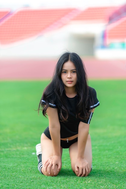 Junge schöne asiatische Frau trägt Fußballspieler, jubelt Sport. Weibliche Fans jubeln Fußballspiel zu