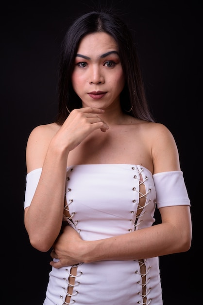 junge schöne asiatische Transgenderfrau gegen Schwarz