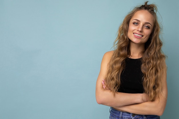 Junge schöne blonde Frau mit schwarzem Top-T-Shirt mit Blick auf die Kamera came