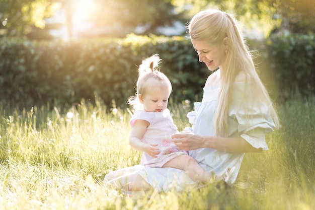 Junge schöne blonde Mutter mit ihrem Baby, das zusammen lacht