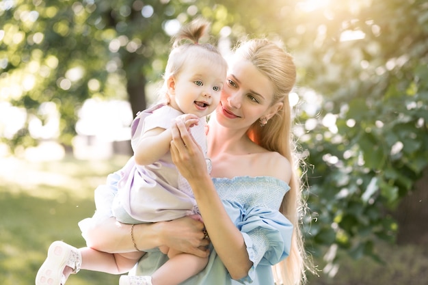 Junge schöne blonde Mutter mit ihrem Baby, das zusammen lacht