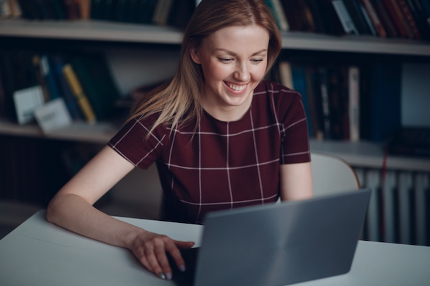 Junge schöne blonde Studentin mit Laptop