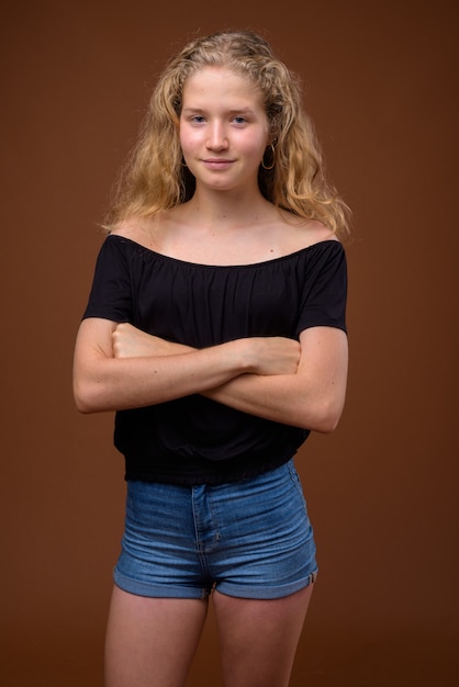 Junge schöne blonde Teenager-Mädchen auf braun