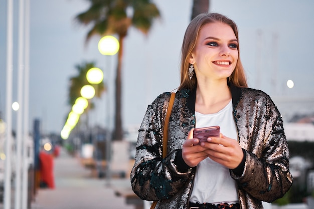 Junge schöne Blondine, die sms Mitteilungen gehen und schreiben