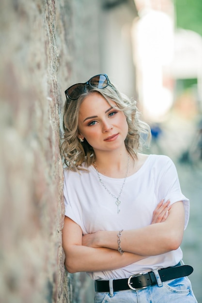 Junge schöne Blondine mit blauen Augen im Zentrum einer europäischen Stadt Porträt eines stilvollen Modells in Freizeitkleidung Glückliche Jugend