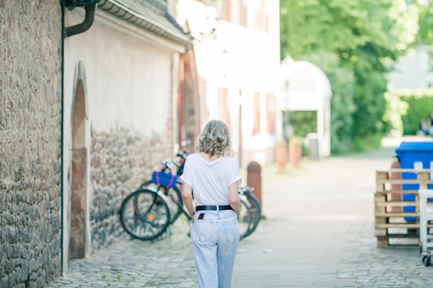 Junge schöne Blondine mit blauen Augen im Zentrum einer europäischen Stadt Porträt eines stilvollen Modells in Freizeitkleidung Glückliche Jugend