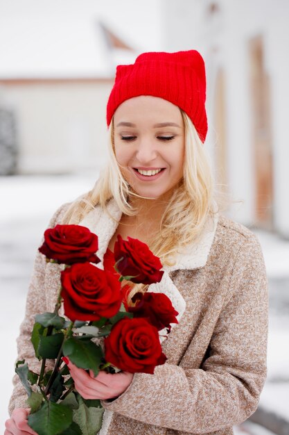 Junge schöne Blondine mit Strauß roter Rosen am Valentinstag