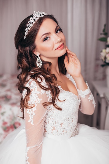Junge schöne Braut mit brünetter Hochzeitsfrisur und Make-up