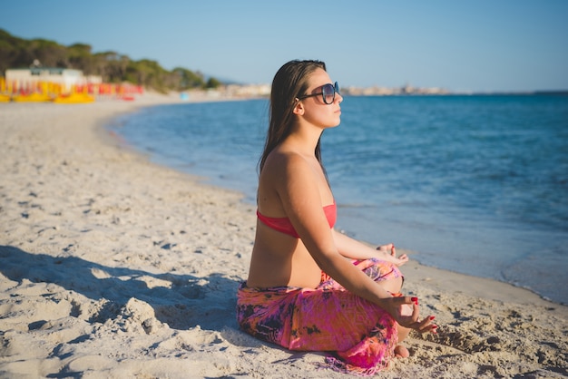 junge schöne Brünette Frau macht Yoga