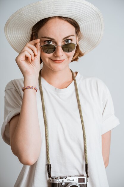 Junge schöne Fotografin mit Strohhut