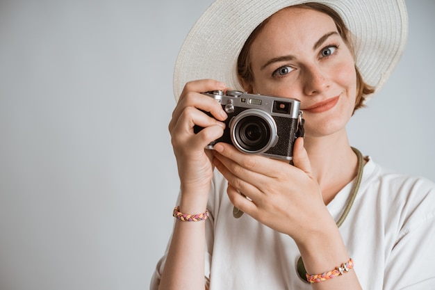 Junge schöne Fotografin mit Strohhut