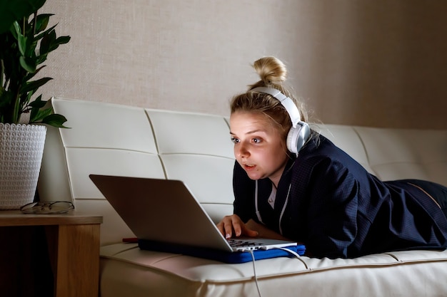 Junge schöne Frau arbeitet für einen Computer von zu Hause aus mit einem Laptop als Freiberufler.