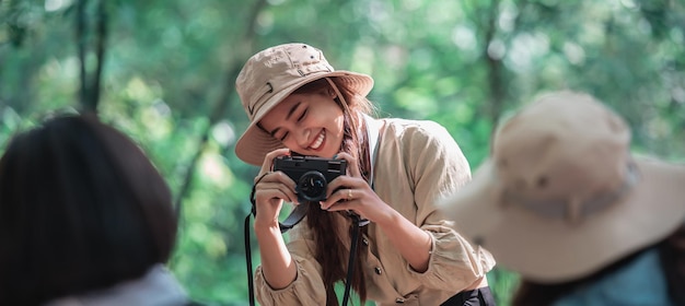 Junge schöne Frau benutzt die Kamera, um ihre Freunde zu fotografieren.