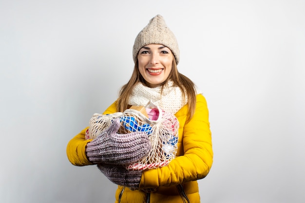 Junge schöne Frau, die Hut des Weihnachtsmannes mit den Einkaufstaschen lokalisiert trägt