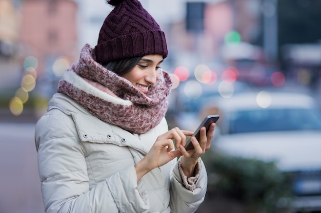 Foto junge schöne frau, die ihr handy benutzt