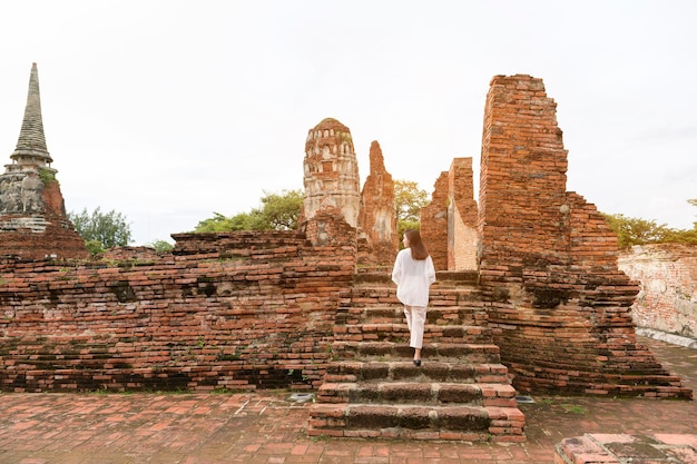 Junge schöne Frau, die im thailändischen historischen Park reist und fotografiert