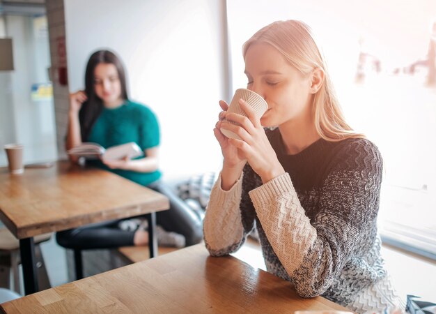 Junge schöne Frau, die Kaffee an der Cafébar trinkt. Weibliches Modell morgens im Restaurant.