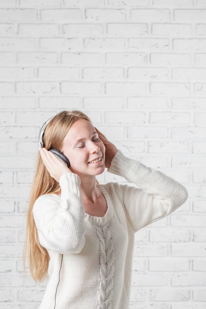 Junge schöne Frau, die Musik mit Kopfhörern hört