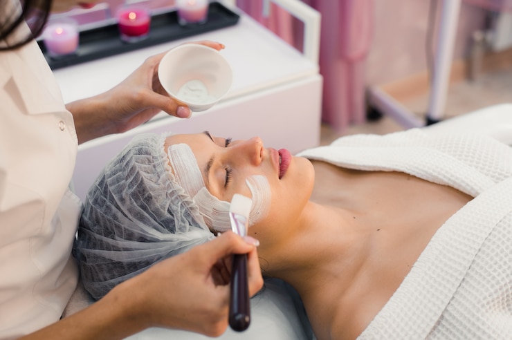 Foto junge schöne frau, die spa-prozedur auf ihrem gesicht hat