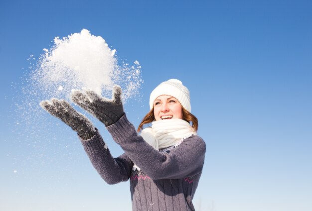 Junge schöne Frau, die Spaß am hellen Wintertag hat