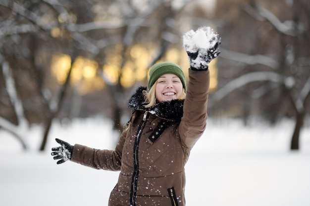 Junge schöne Frau, die Spaß im Winterpark hat