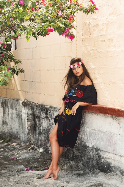 Junge schöne Frau, die traditionelles mexikanisches Kleid auf der Stadtstraße trägt