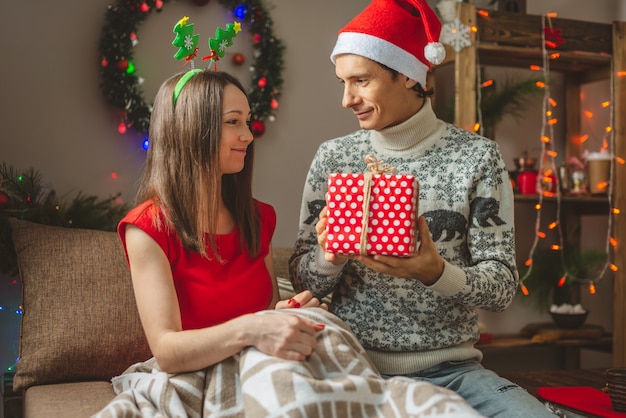 Junge schöne Frau Frau gibt ihrem Mann eine Überraschungsgeschenkbox