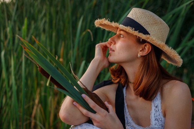 Junge schöne Frau im Boho-Stil Kleid und Hut in der Natur