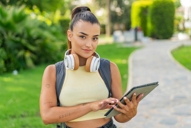 Junge schöne Frau im Freien mit einem Tablet