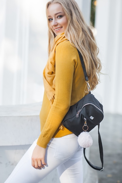 Junge schöne Frau im Freien. Nahaufnahmeporträt des fröhlichen Ladyon-Frühlings- oder Herbsthintergrunds. Mädchen mit Rucksack.
