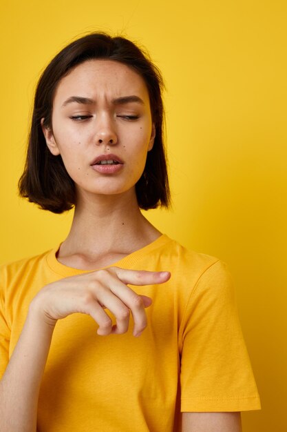 Junge schöne Frau im gelben T-Shirt, das den unveränderten Lebensstil der Mode aufwirft