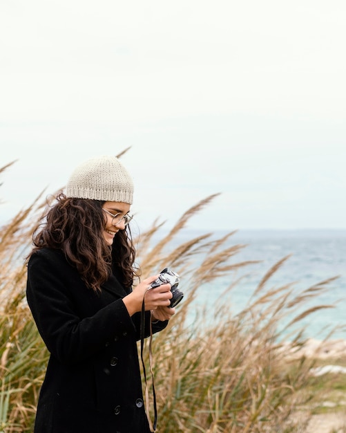 Foto junge schöne frau in der natur mit kamera