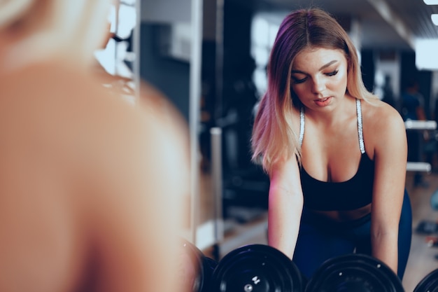 Junge schöne Frau in Sportbekleidung in einem Fitnessstudio