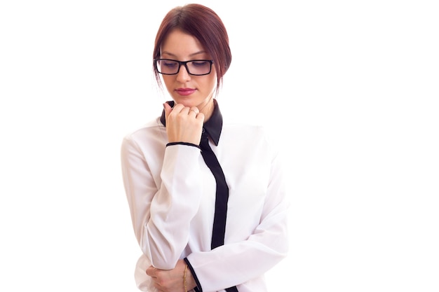 Junge schöne Frau in weiß-schwarzem Hemd mit schwarzer Brille auf weißem Hintergrund im Studio