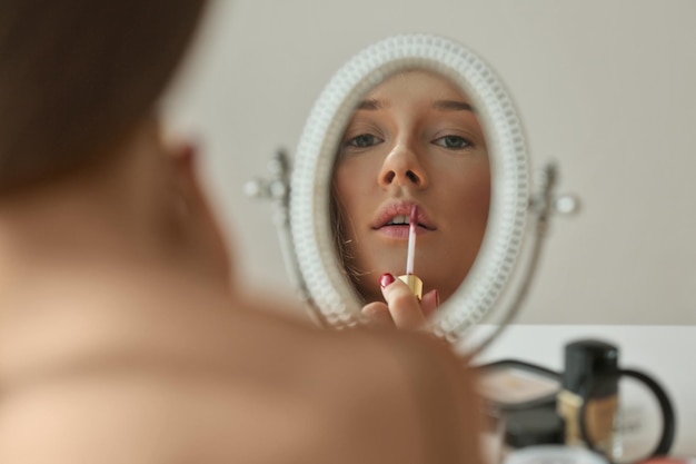 Junge schöne Frau macht ihr Make-up