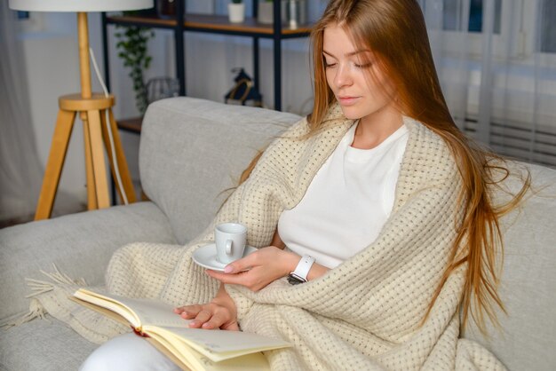 junge schöne frau mit buch zu hause verbringt morgens oder abend