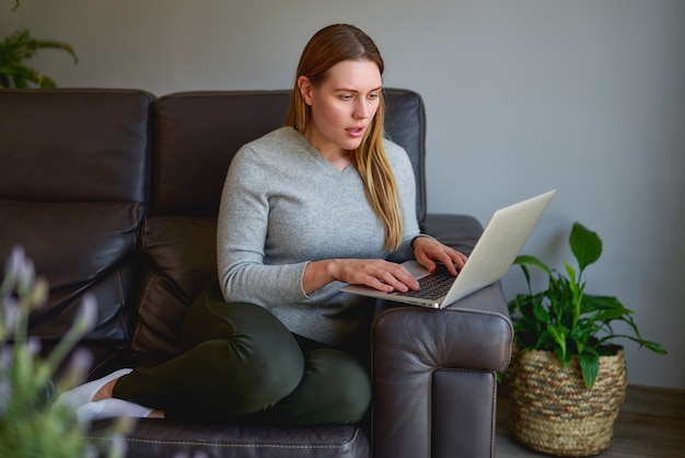 Junge schöne Frau mit einem Laptop-Computer zu Hause