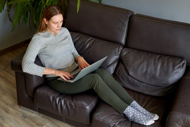 Junge schöne Frau mit einem Laptop-Computer zu Hause