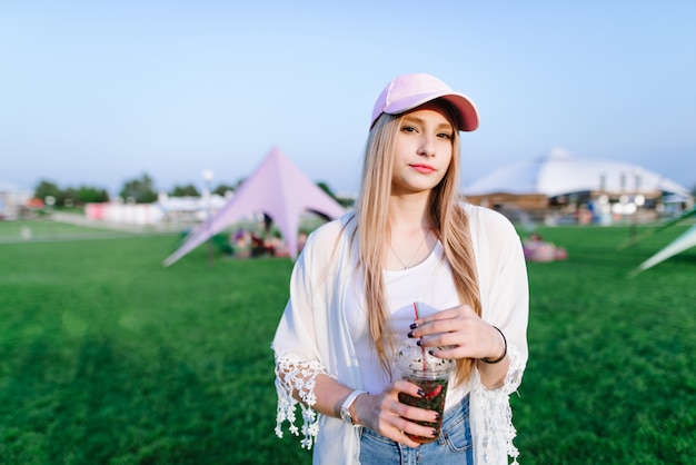 Junge schöne Frau mit einer Kappe an einem Sommerfest