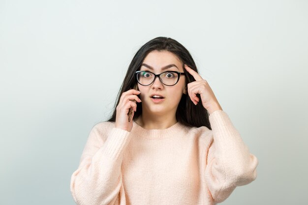 Junge schöne Frau mit Handy-Studio auf weißem Hintergrund Blick aufmerksam auf den Bildschirm des Handys, der Webseiten durchsucht