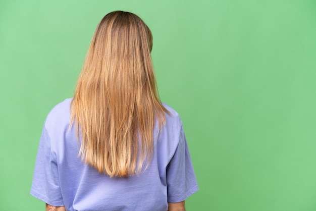 Junge schöne Frau mit isoliertem Hintergrund in Rückenposition und seitlichem Blick