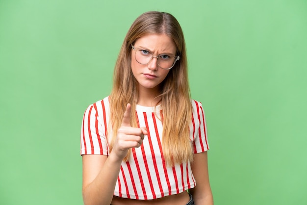 Foto junge schöne frau mit isoliertem hintergrund ist frustriert und zeigt nach vorne