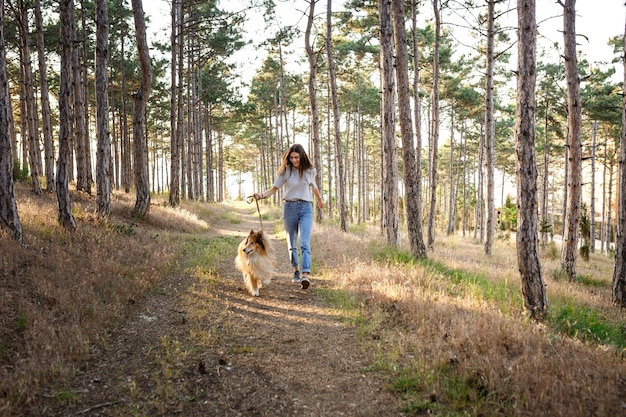 Junge schöne Frau mit langen Haaren, die mit Colliehund gehen. Draußen im Park. in der Nähe des Meeres, Sommer Beatch